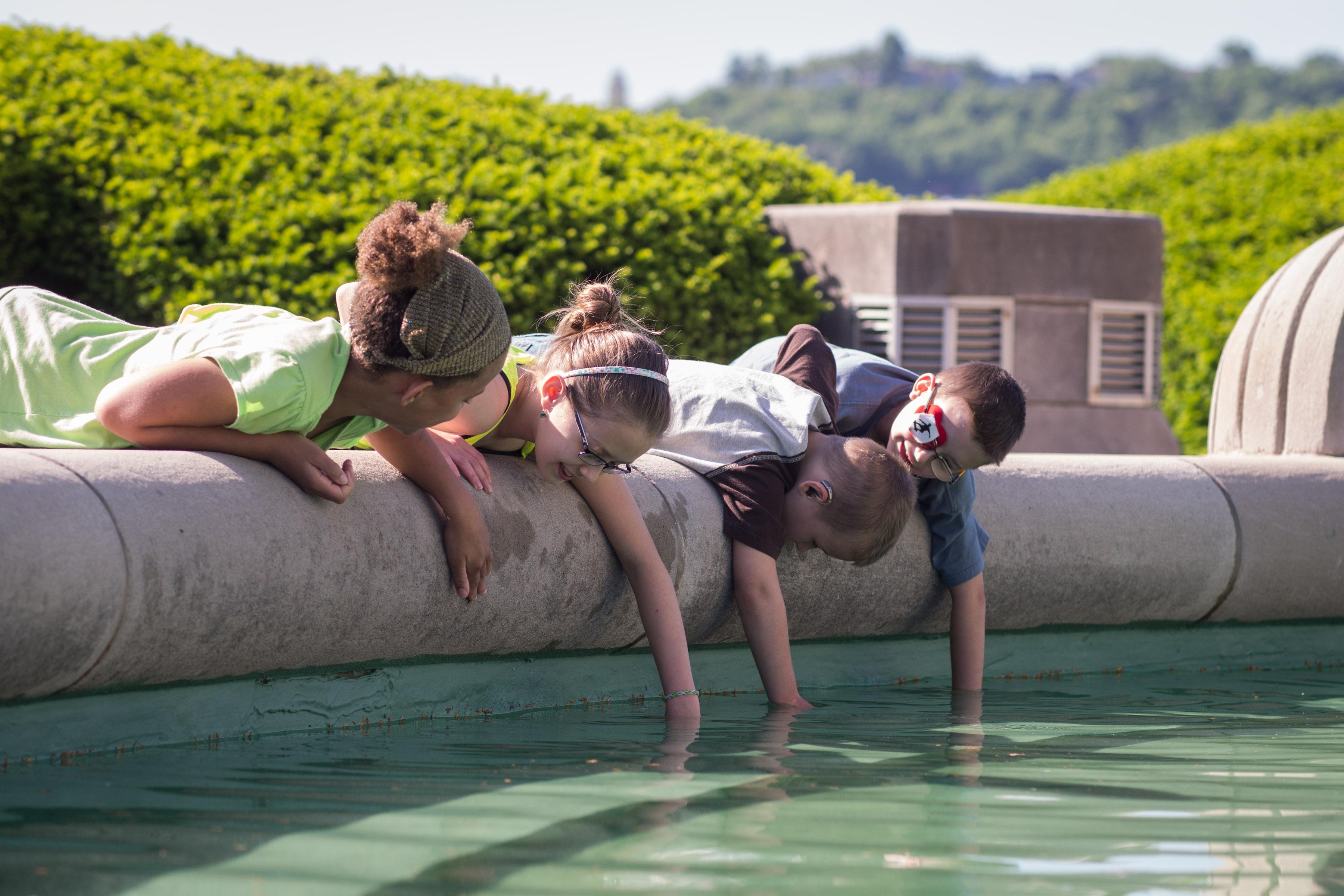 children interacting with the 结合终端 fountain in the summer